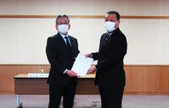 時田部会長から計画案の報告を受ける永田市長(左)
