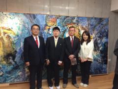 画像　水上氏の作品の前で記念撮影をする永田市長（右から2人目）