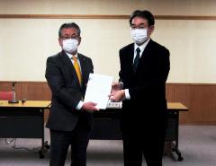 島野委員長から計画案の報告を受ける永田市長（左）